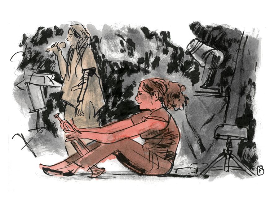 Airelle Besson: Trumpeter sitting on the stage floor while a singer performs behind her