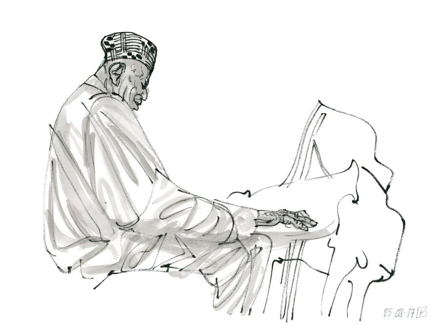 Randy Weston: Randy Weston in a patterned cap at the piano, grey wash
