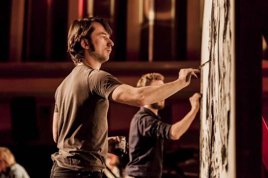 Stage photo: the two artists drawing side by side